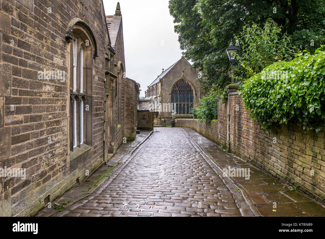 Passerella di pietra lungo il lato della chiesa, Haworth, West Yorkshire, Inghilterra Foto Stock