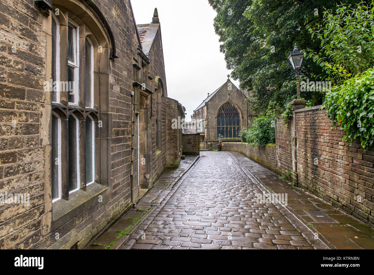 Passerella di pietra lungo il lato della chiesa, Haworth, West Yorkshire, Inghilterra Foto Stock