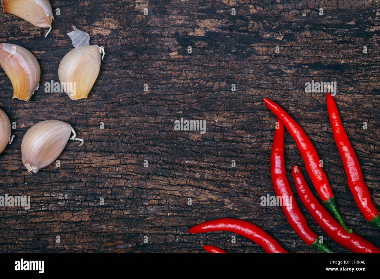 Il peperoncino e aglio su uno sfondo di legno con lo spazio vuoto per il testo piccante e speziato per Sfondo menu Foto Stock