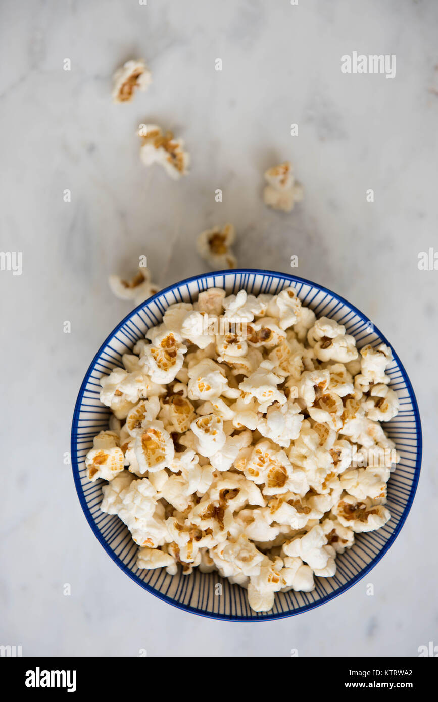 Preparata di fresco di popcorn in blu e bianco ciotola su marmo Foto Stock