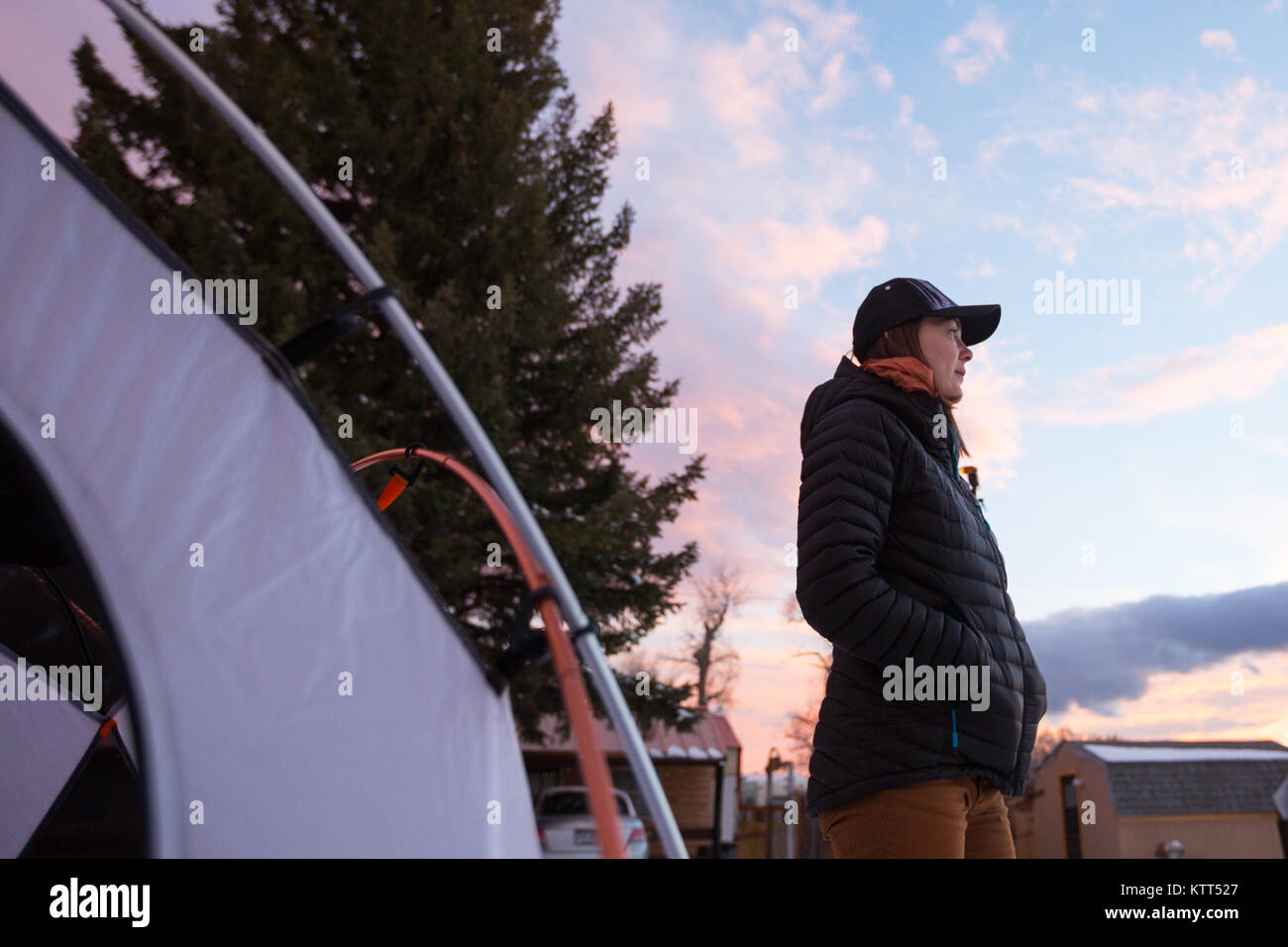 Donna in piedi accanto alla tenda sul campeggio stradale, Wyoming, Stati Uniti Foto Stock