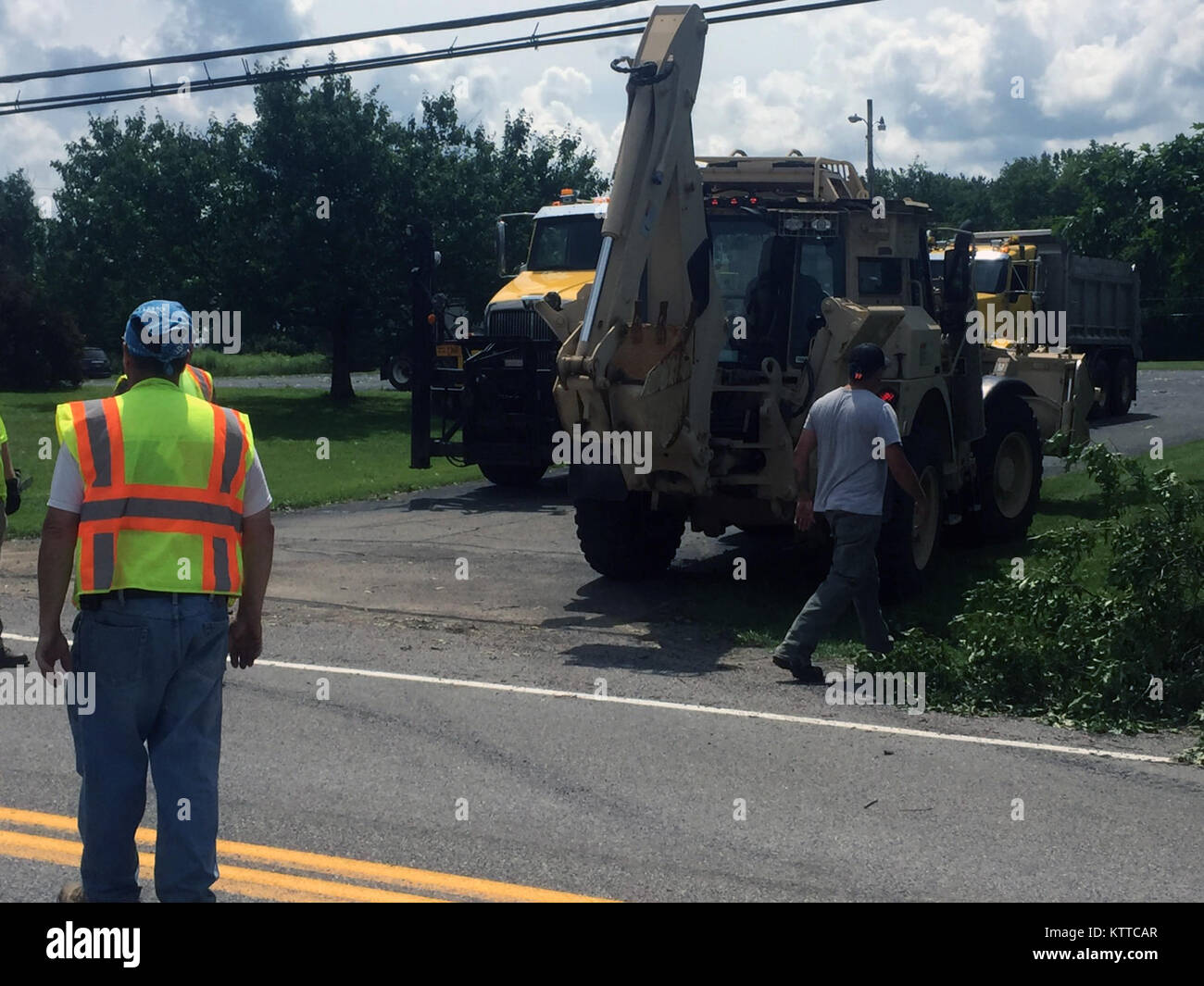A New York esercito Guardia Nazionale ad alta mobilità escavatore ingegnere conduce linkup iniziale con la Contea di Erie Dipartimento Autostradale nei pressi di Olanda, New York seguenti tornado danni provocati dalla tempesta sulla luglio 20, 2017. New York Army National Guard per tecnici e ingegneri provenienti da società A, XXVII Brigata truppe speciali battaglione sono parte di 100 stati comune di Guardia Nazionale elemento di risposta per assistere i soccorritori di emergenza con gli sforzi di recupero. Un tornado toccato in Erie County nella parte occidentale dello Stato di New York, lasciando un iniziale 20.000 residenti senza alimentazione e downing poteri linee e alberi, bloccando le strade locali con debri Foto Stock
