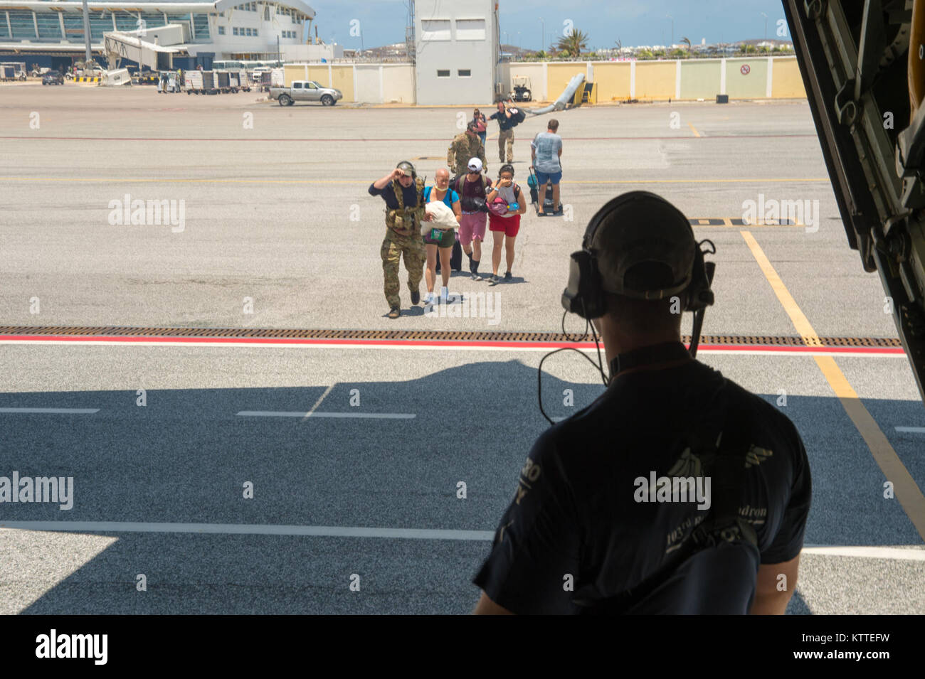 Membri dalla 106ª Ala di salvataggio aiutare gli sfollati dalla distrutta aeroporto su St Maarten su un HC-130 mettetevi comodi e di sentirsi al sicuro come si preparano per portarli a San Juan, Puerto Rico. Il New York Air National Guard la 106ª Ala di salvataggio, staging fuori di San Juan, Puerto Rico con la 156aria parafango sollevamento forniscono il supporto per il salvataggio di coloro che sono nel bisogno su St Maarten. La 106ª portato due HC-130 re aeromobili, tre HH-60 Pave Hawk elicotteri, tre zodiac barche e 124 aviatori necessaria per svolgere la missione. Foto Stock
