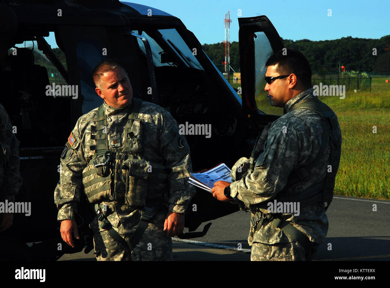 Army Chief Warrant Officer 3 Matt Quackenbush, destro fornisce un equipaggio briefing per il Mag. Paolo Bailie come personale di volo della New York Army National Guard per la società A, 3° Battaglione, 142th reggimento aviazione pronti per il decollo e la distribuzione da Albany International Airport in Latham, N.Y. a Florida a sostegno della risposta di guardia per Hurricane Irma Settembre 11, 2017. Dieci UH-60 Blackhawk elicotteri e 55 equipaggi iscritti e i manutentori distribuito da tre strutture di volo in tutto lo stato per sostenere la Florida Esercito nazionale di protezione. Stati Uniti La Guardia Nazionale foto da Col. Richard Goldenberg. Foto Stock