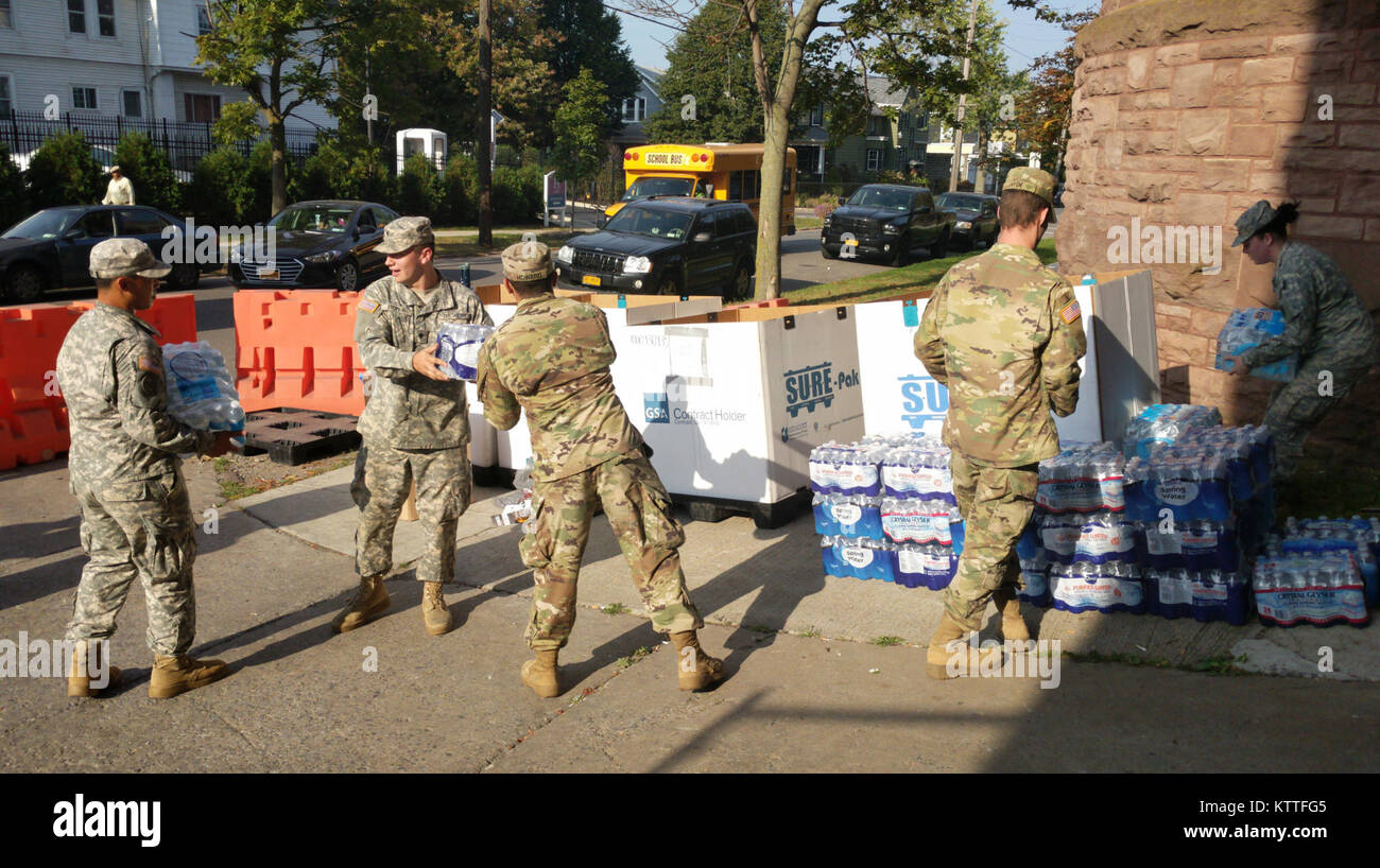 Army Spc. Jason Stopka, centro, aiuta a superare i casi di donato di acqua a Spc. Nigel Howard a New York La Guardia Nazionale di donazione del punto di raccolta presso il Connecticut Street Armory di Buffalo, N.Y. Dulinawka, insieme con altri soldati del ventisettesimo brigata truppe speciali battaglione, ha contribuito a raccogliere donazioni per Puerto Rico e Stati Uniti Isole Vergini come parte di New York del sostegno per gli sforzi di recupero dopo gli uragani di Irma e Maria. Il New York La Guardia Nazionale ha più di 700 soldati e aviatori sostenendo gli sforzi di recupero, dalla marcia avanti aeromobili impiegati e personale per il supporto di 14 donazione cen Foto Stock