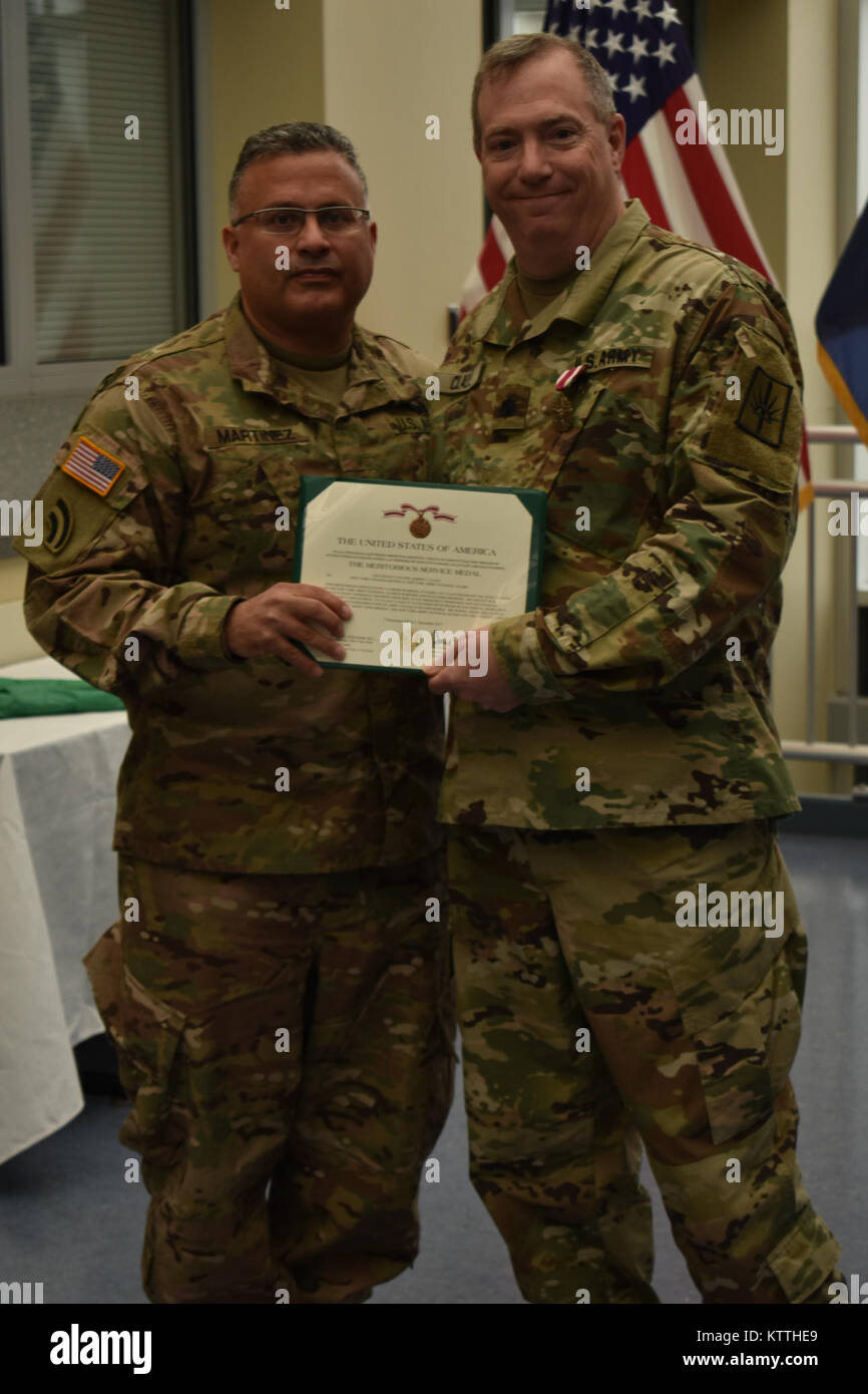 N.Y. Esercito Nazionale soldato di guardia, Col. David Martinez (sinistra), presenta Lt. Col. Giuseppe Claus(a destra) con il meritorio medaglia di servizio durante la sua cerimonia di pensionamento, in Latham, N.Y., Dicembre 2, 2017. Lt. Col. Claus era in pensione dopo 30 anni di servizio.(N.Y. Esercito nazionale Guard foto di Spc. Andrew Valenza) Foto Stock