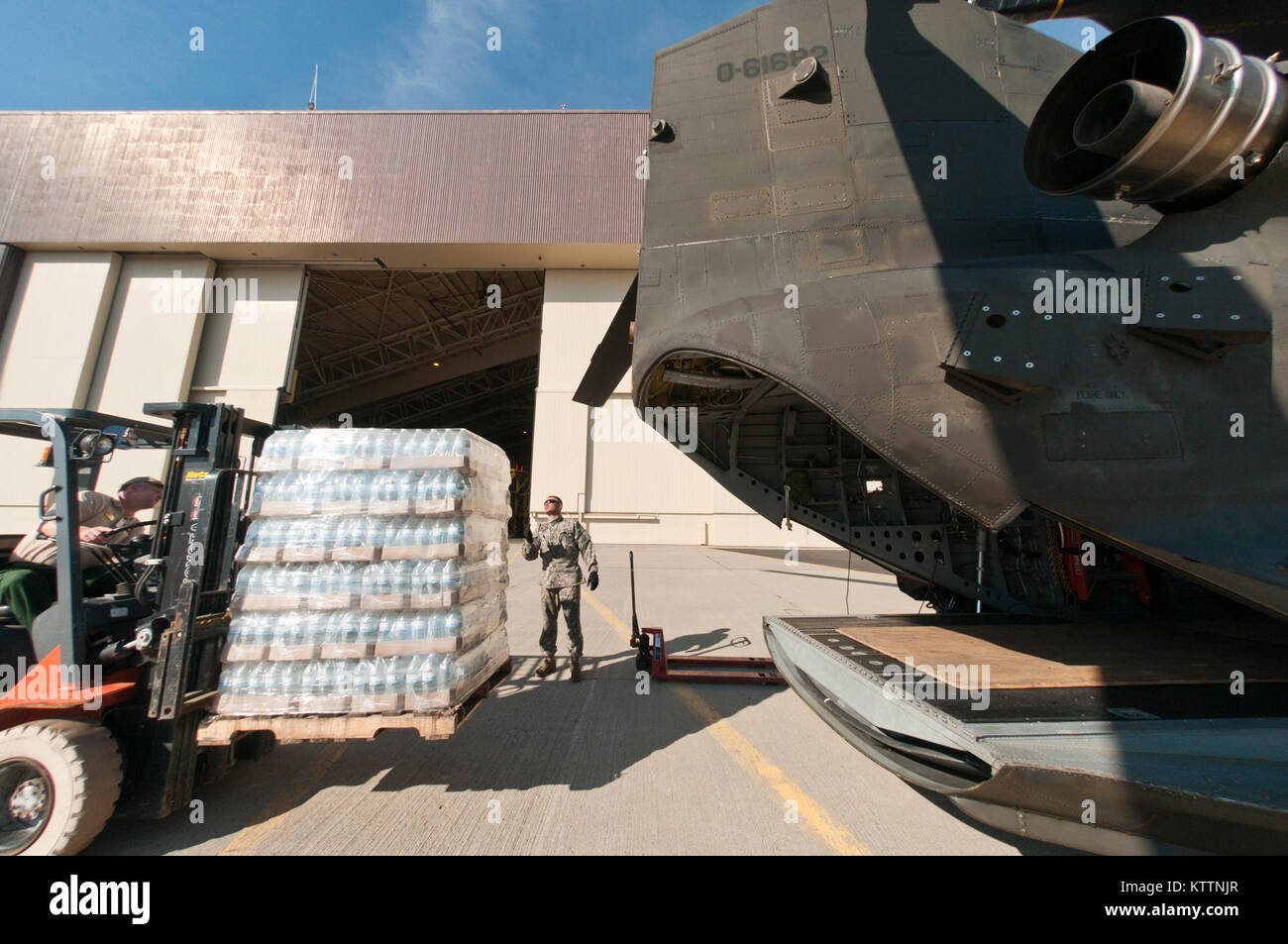 STEWART ANGB, Newburgh, N.Y. -Personale Sgt. Herley, B Co.3a BN126 Reggimento aviazione NYARNG, dirige l'operatore carrello elevatore a forche David Whitaker, FEMA, durante il caricamento di un pallet di bottlee acqua in un elicottero Chinook a sostegno dell'Uragano Irene operazioni di recupero il 31 agosto, 2011. (U.S. Air Force Foto di Tech. Sgt. Michael OHalloran)(rilasciato) Foto Stock