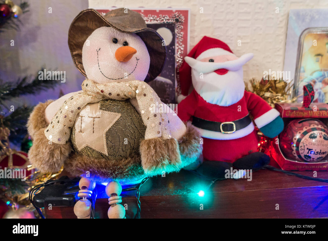 Un mantelpiece decorata con decorazioni di Natale incluso albero di Natale luci, peluche e carte di Natale. Foto Stock