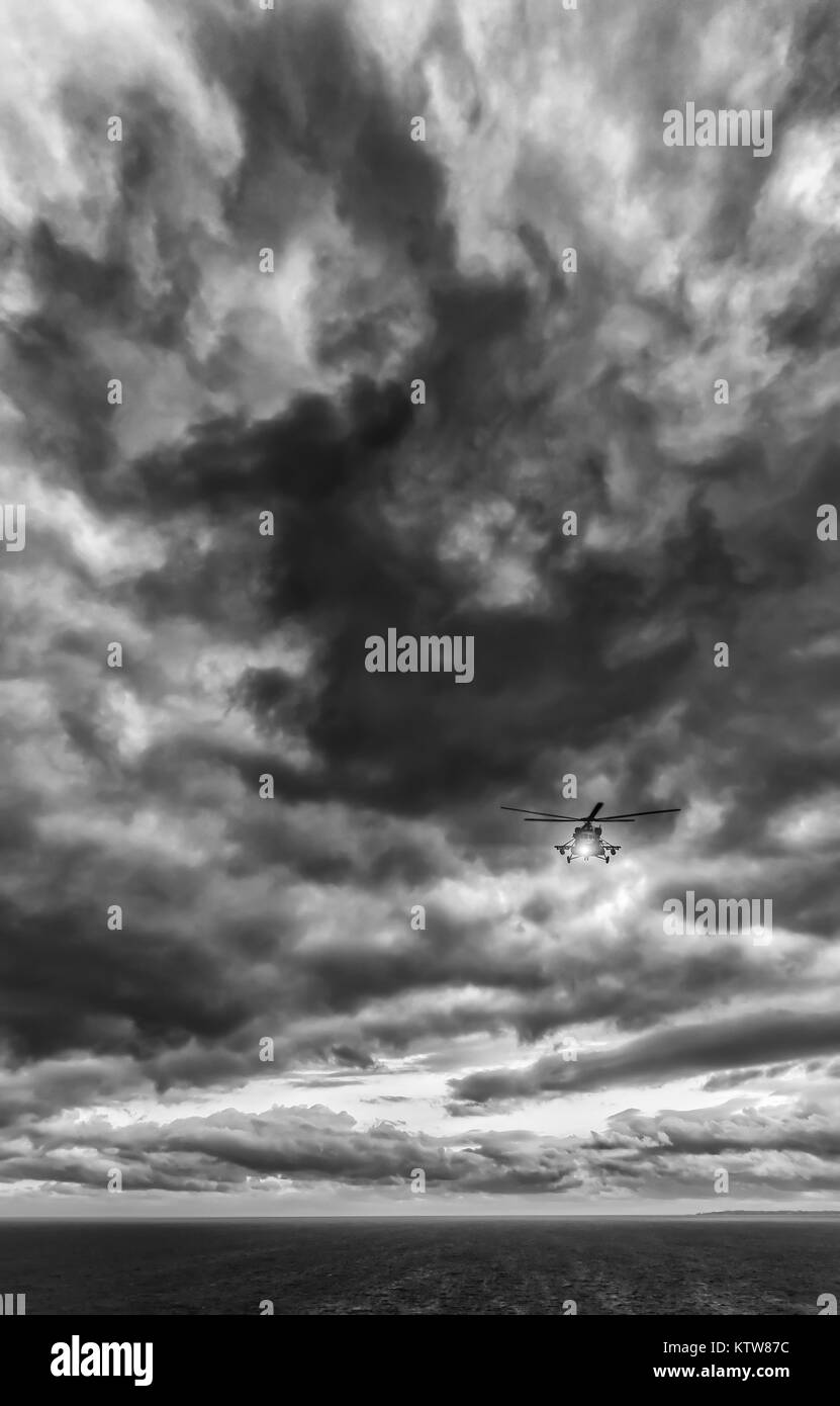 Tempesta di mare, elicottero Mi-8 dal di sotto di fronte drammatico cielo cielo tempestoso Foto Stock