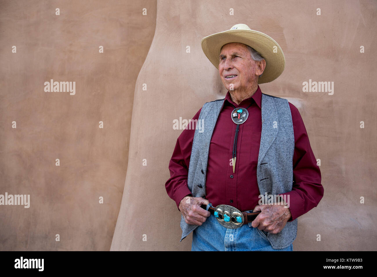 Il vecchio cowboy in posa di fronte di adobe su San Fransicso Street, Santa Fe, New Mexico Foto Stock