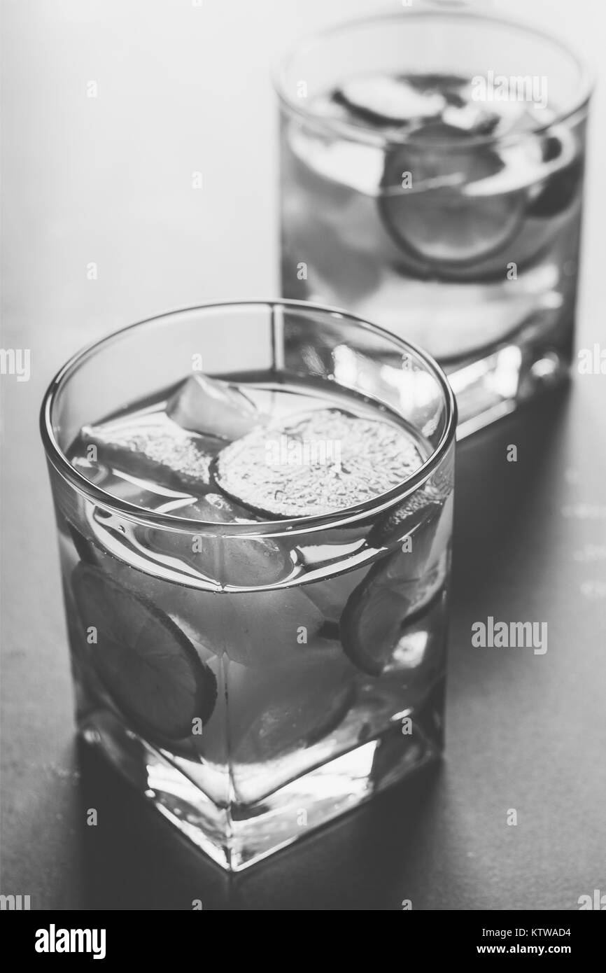 Un cocktail rinfrescante con limone e ghiaccio close up, foto in bianco e nero Foto Stock