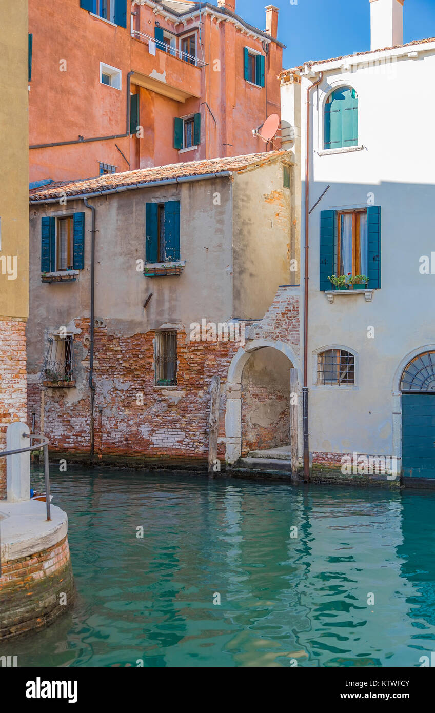Un frammento di un edificio in mattoni e la discesa per il canale dell'acqua. Venezia. Italia Foto Stock