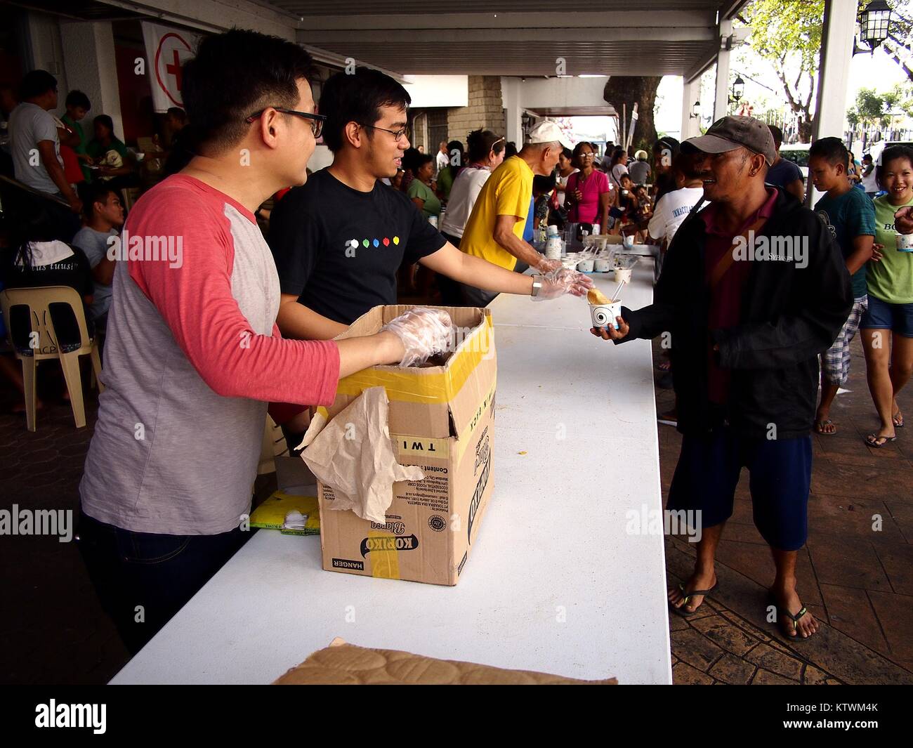 ANTIPOLO City, Filippine - 23 dicembre 2017: volontari dare il cibo nel corso di un programma di alimentazione in corrispondenza di una chiesa. Foto Stock