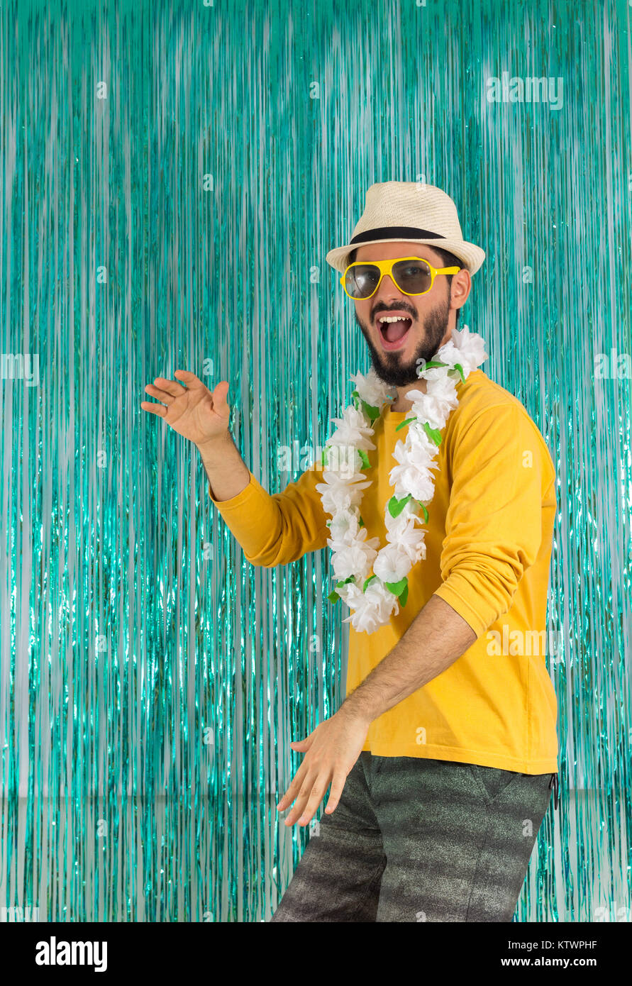 Uomo Barbuto in verde e giallo vestiti, occhiali da sole e Collane Hawaiane.  Il Carnevale del Brasile, vigilia della festa di fine anno, euforia e  divertimento. Colorate e luminose Foto stock -