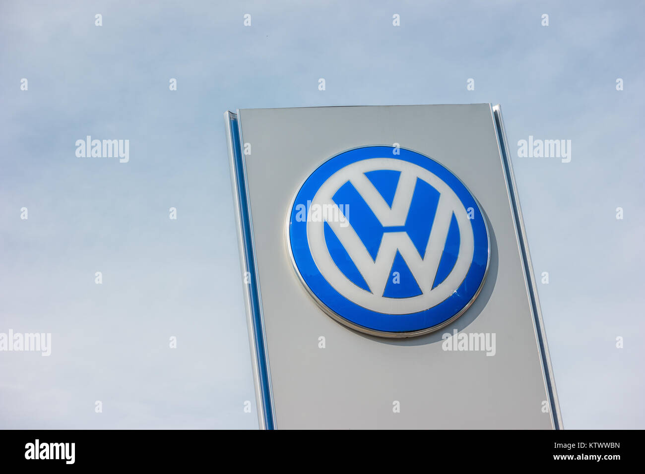 Volkswagen segno contro il cielo nuvoloso. Volkswagen è la più grande casa automobilistica tedesca e la terza più grande fabbricante automobilistico in tutto il mondo Foto Stock