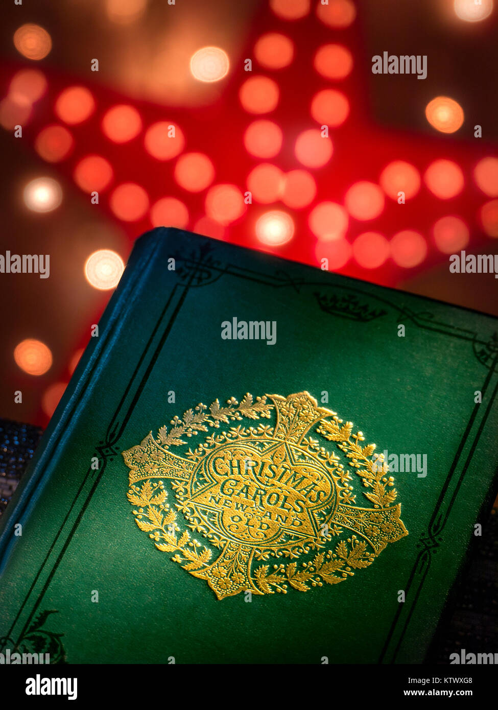 Christmas Carols canzone cantare 'New and Old' musica copertina libro con caldo invitante Natale luci dietro. Foto Stock