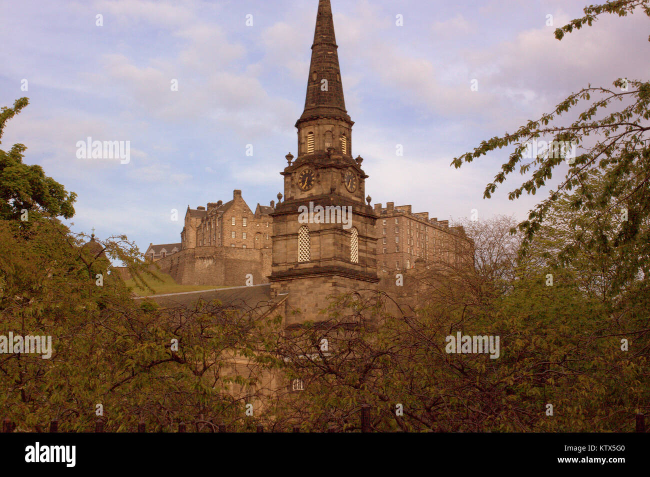 Il campanile della chiesa parrocchiale di St Cuthbert, Lothian Road, Edimburgo, Regno Unito con il castello come sfondo Foto Stock