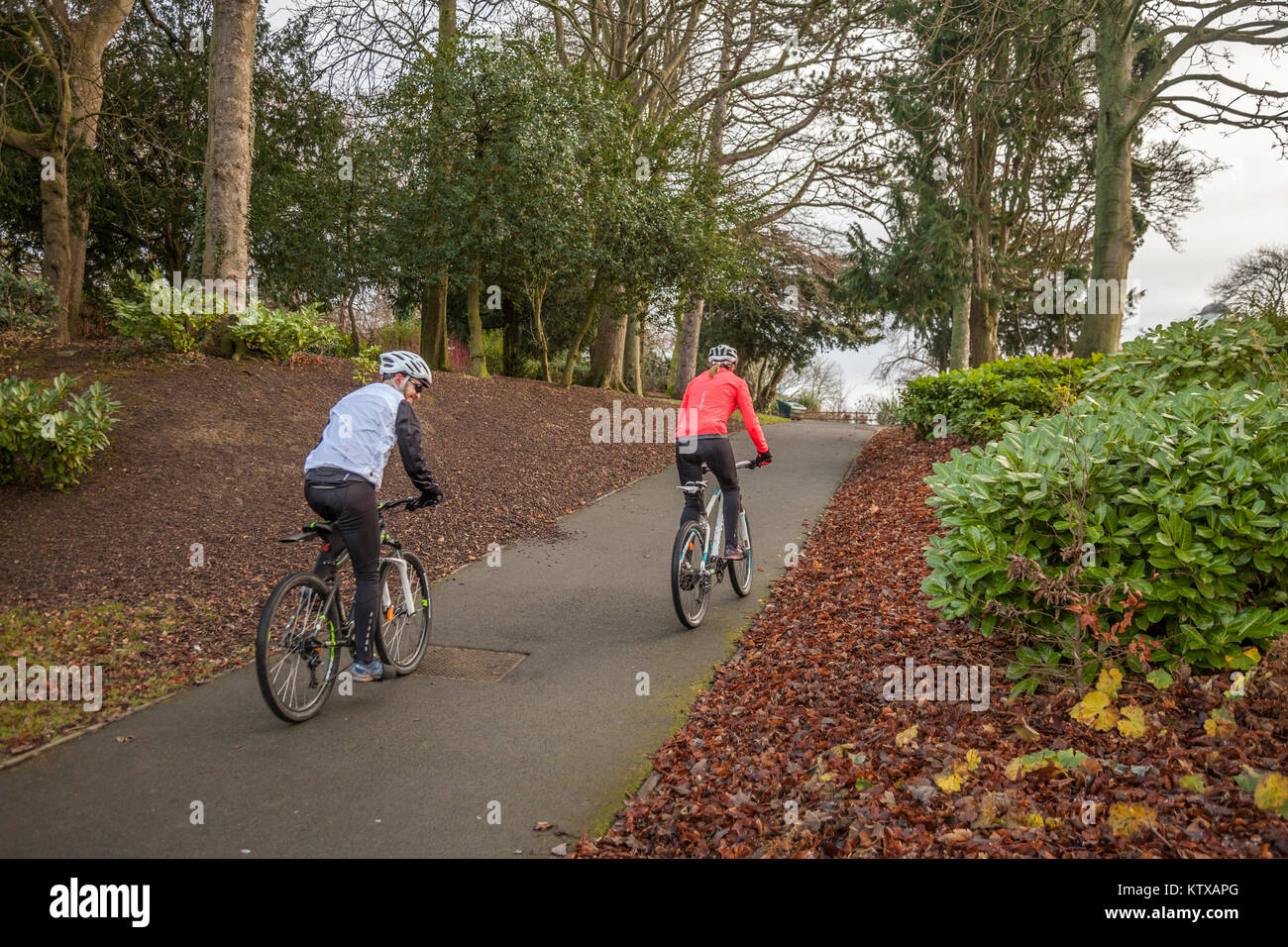 Un uomo e una donna un ciclo attraverso Ropner Park, Richmond Road, Stockton-on-Tees, Regno Unito Foto Stock