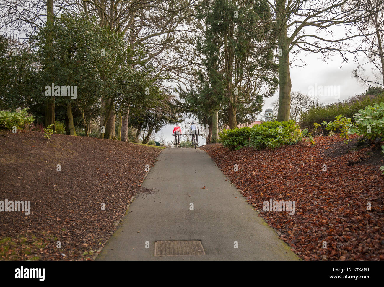 Un uomo e una donna un ciclo attraverso Ropner Park, Richmond Road, Stockton-on-Tees, Regno Unito Foto Stock