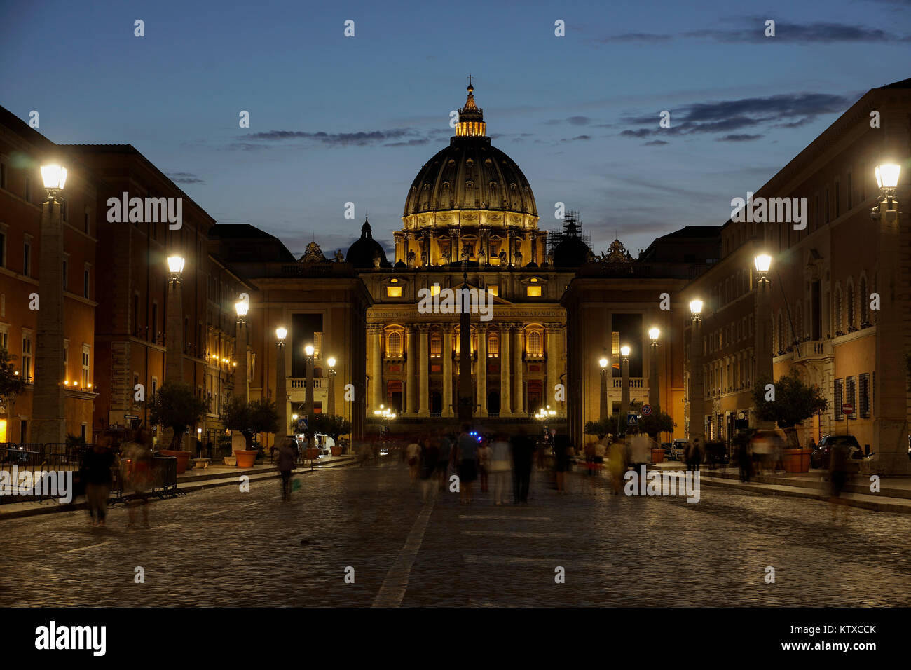 La Cattedrale di San Pietro vista notturna con passaggio di folla e da Via della Conciliazione in Roma, Lazio, l'Italia, Europa Foto Stock