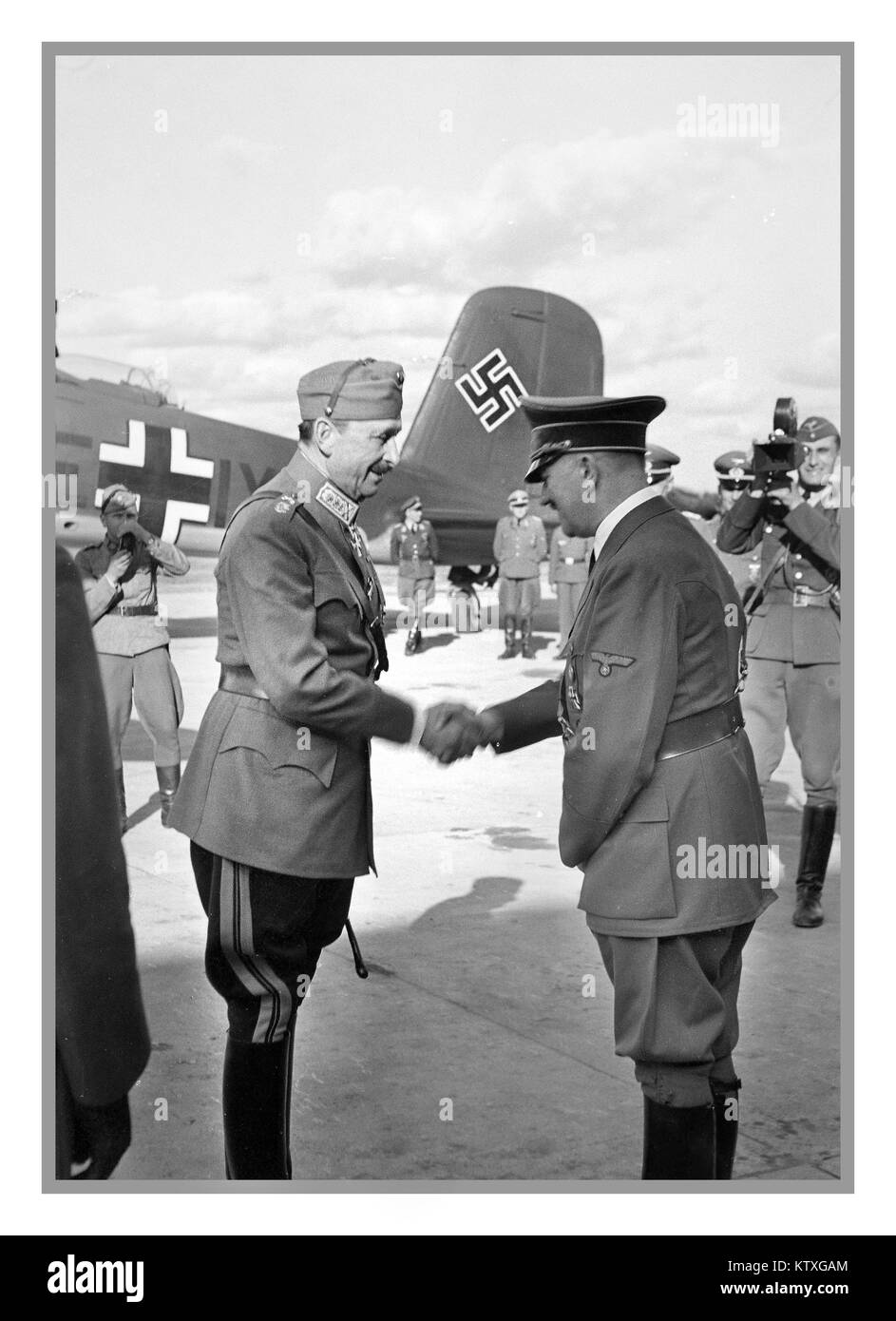 MANNERHEIM & HITLER Field Marshal Carl Gustav Mannerheim saluta Adolf Hitler il 4th 1942 giugno con Hitlers Luftwaffe Focke-Wulf 200 Swastika pinna di coda in background. Fu il 75th° compleanno del maresciallo finlandese Carl Gustav Mannerheim. Adolf Hitler ha colto l'occasione per volare in Finlandia per congratularsi personalmente con Mannerheim e per discutere di molti importanti temi l'incontro si è svolto nella Finlandia orientale, nella zona del campo aereo di Immola, vicino alla città di Imatra. Dopo quell'incontro Mannerheim giocò una lunga partita in attesa e decise saggiamente di essere un alleato della Germania nazista. Foto Stock