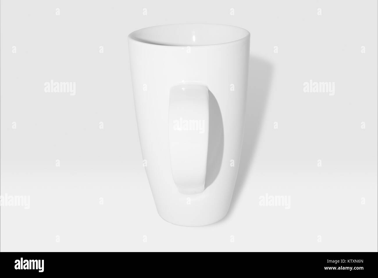 Bianco grande tazza di caffè/coppetta con manico rivolto in avanti: Bianco stoviglie contro uno sfondo bianco,100% in scala di grigi. Foto Stock