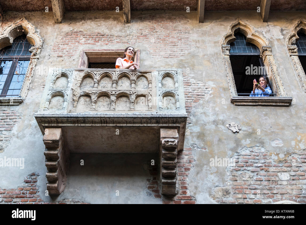 Due ragazze turistici rendendo le foto nel balcone che ha ispirato la tragedia Romeo e Giulietta scritta da William Shakespeare. La Casa di Giulietta, Verona, Foto Stock