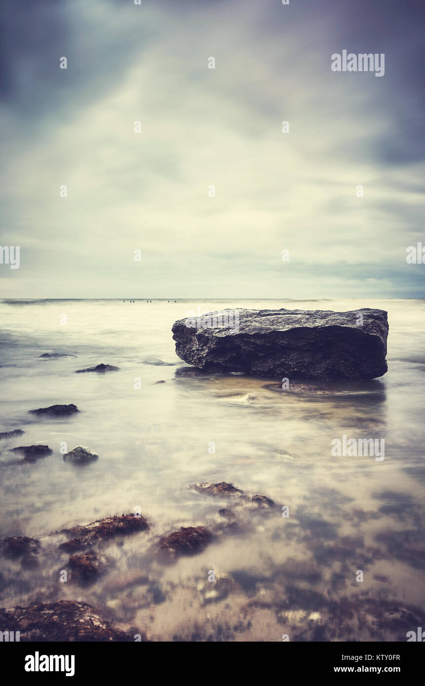 Roccia su una spiaggia, tranquillo sfondo naturale, dai toni di colore foto, messa a fuoco selettiva. Foto Stock