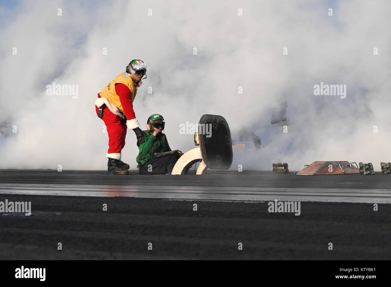 Un U.S. Navy sailor vestiti da Babbo Natale lavora sul ponte di volo dell'U.S. Nimitz Navy-class portaerei USS Theodore Roosevelt 21 dicembre 2017 nel Golfo Arabico. Foto Stock