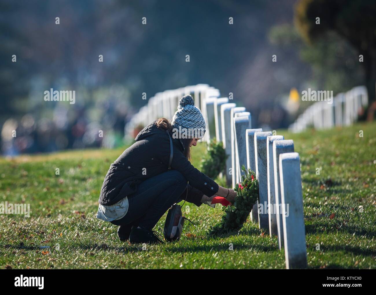 Un volontario stabilisce una corona su una lapide durante ghirlande in tutta l'America presso il Cimitero Nazionale di Arlington, Dicembre 16, 2017 in Arlington, Virginia. Foto Stock
