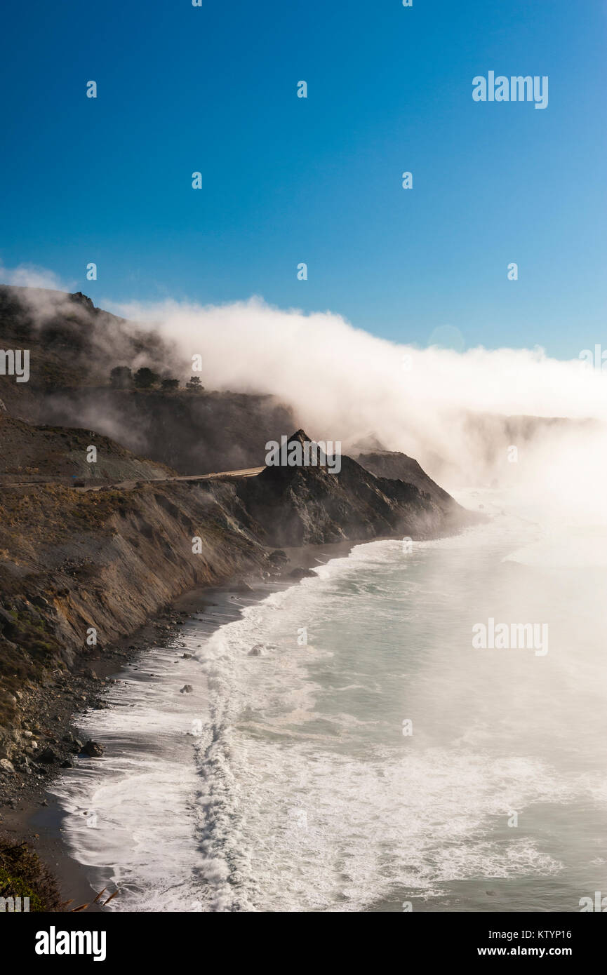 Immagine di panorama di onde frantumazione su una spiaggia in un giorno di nebbia lungo il Big Sur Costa, Cabrillo HWY, membro Route 1, California, Stati Uniti d'America. Foto Stock