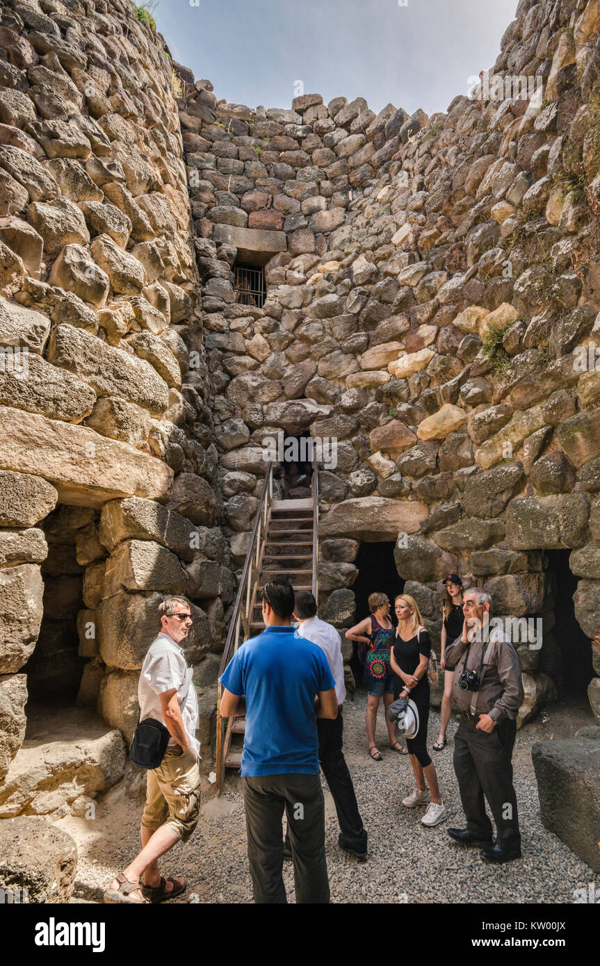 E guida i visitatori al nuraghe Su Nuraxi, xvii secolo a.c. struttura megalitica, Età del Bronzo, vicino a Barumini, Sardegna, Italia Foto Stock