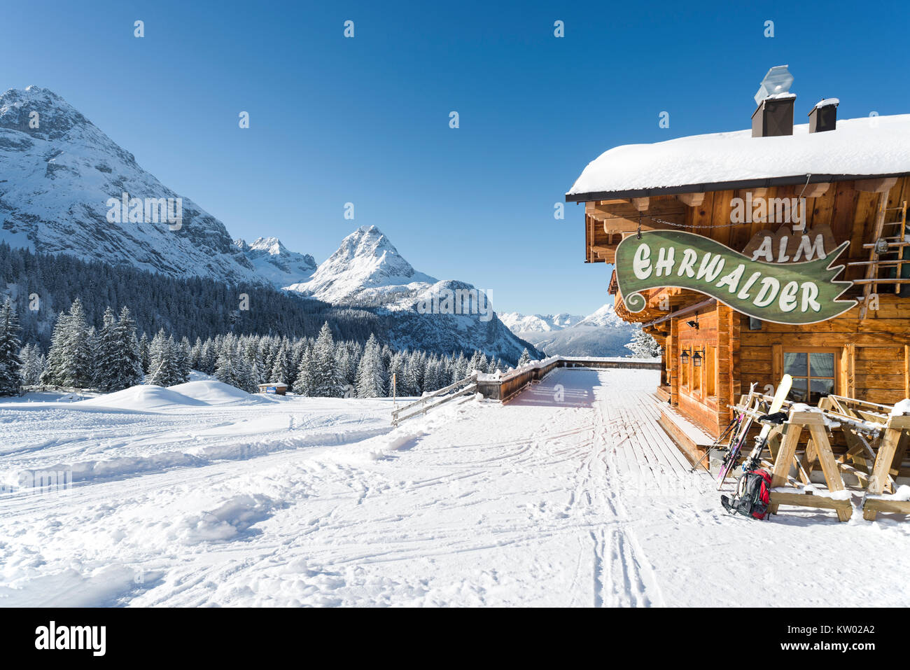 Alpine chalet di legno sul Ehrwalder Alm ski resort circondato da un soleggiato paesaggio innevato , Tirolo, Austria Foto Stock