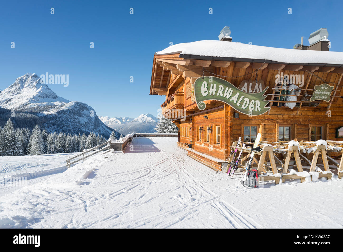 Alpine chalet di legno sul Ehrwalder Alm ski resort circondato da un soleggiato paesaggio innevato , Tirolo, Austria Foto Stock