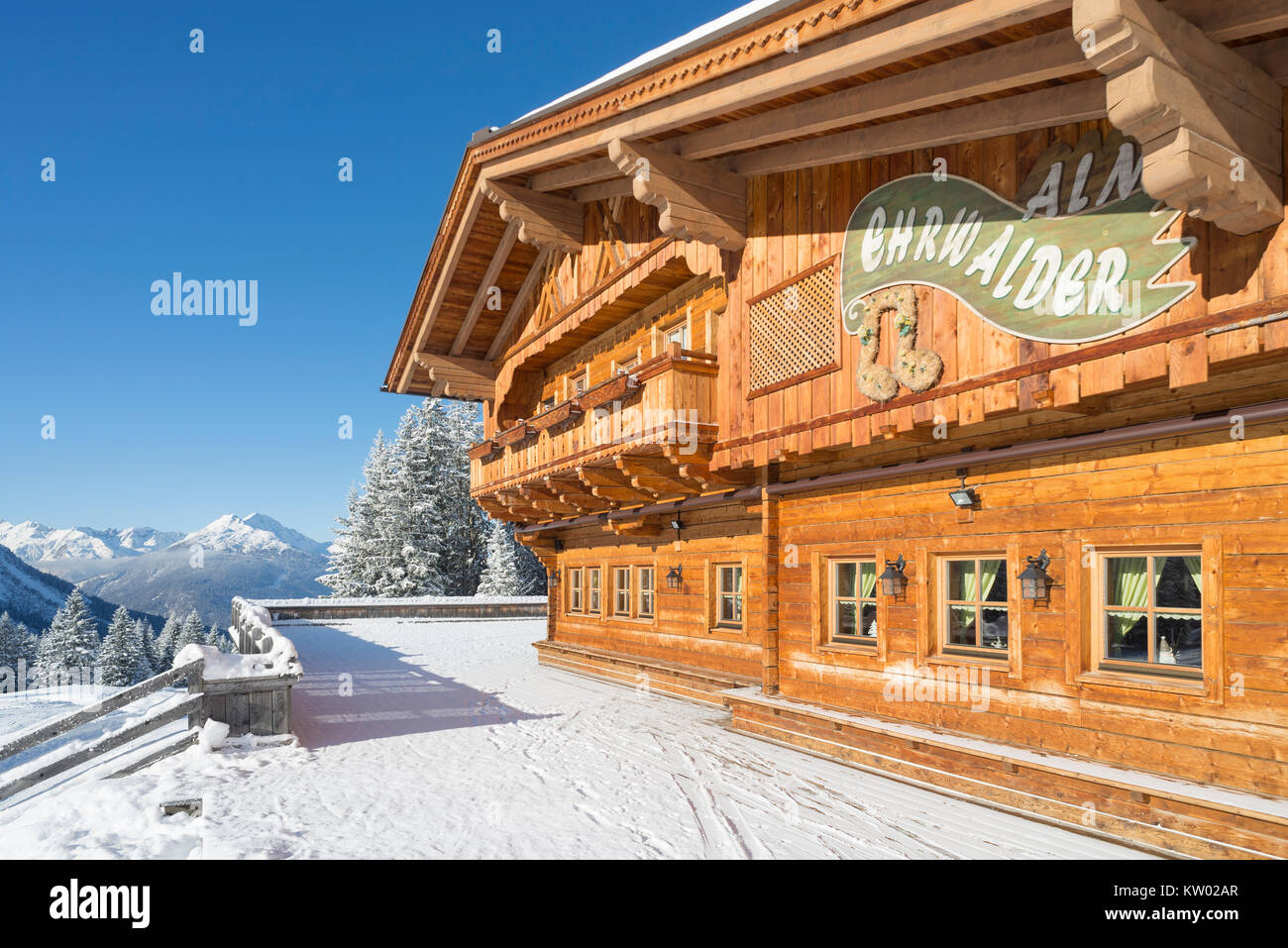 Alpine chalet di legno sul Ehrwalder Alm ski resort circondato da un soleggiato paesaggio innevato , Tirolo, Austria Foto Stock