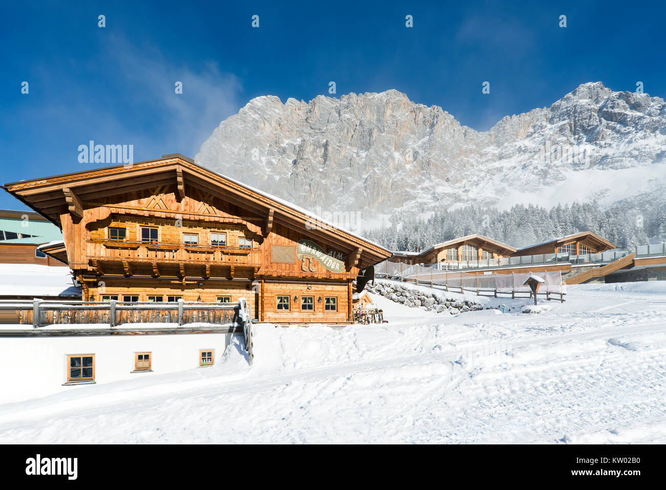 Alpine chalet di legno sul Ehrwalder Alm ski resort circondato da un soleggiato paesaggio innevato , Tirolo, Austria Foto Stock