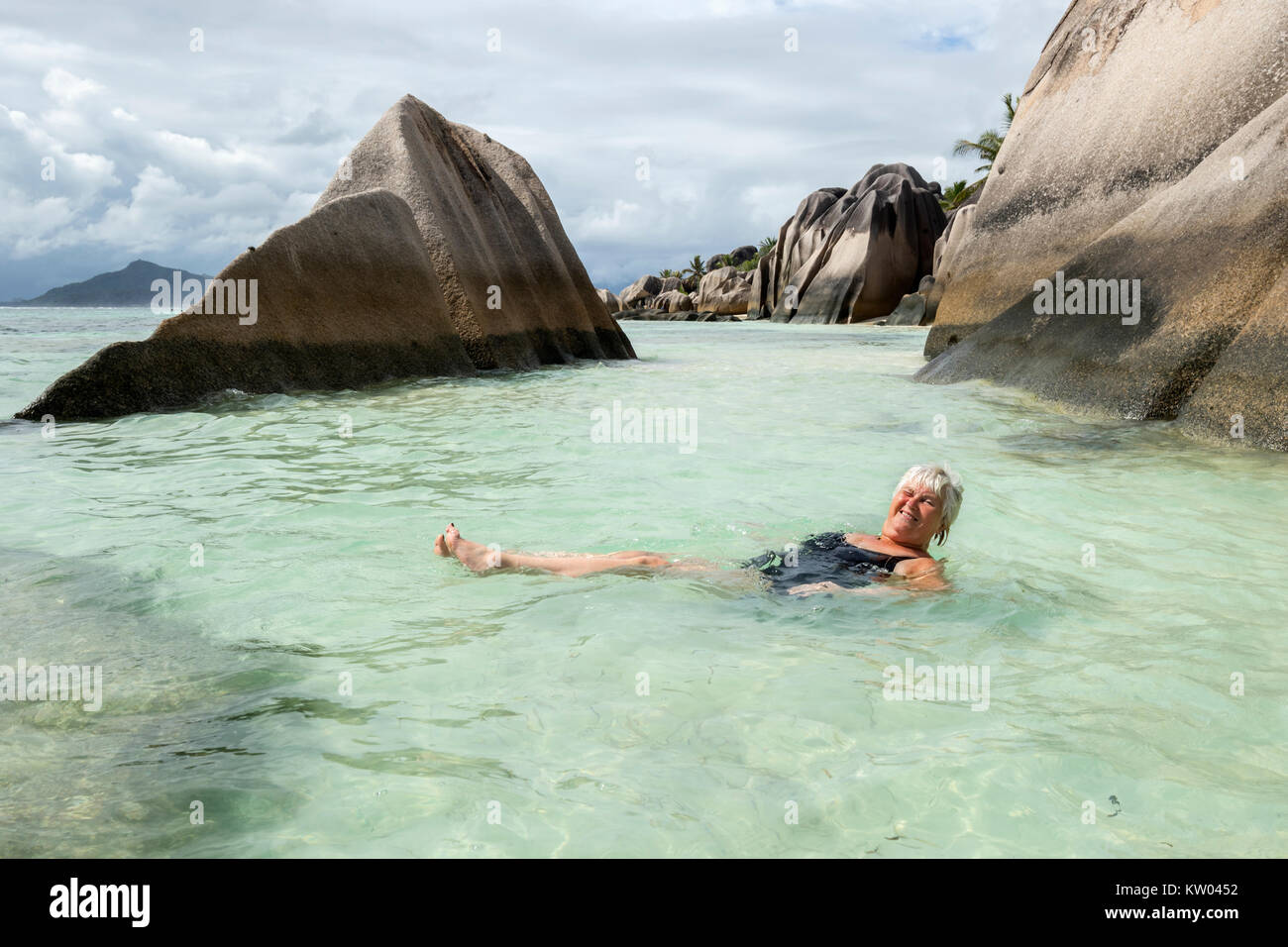 La donna la balneazione sulla spiaggia di Anse Source d'Argent, La Digue, Seicelle Foto Stock