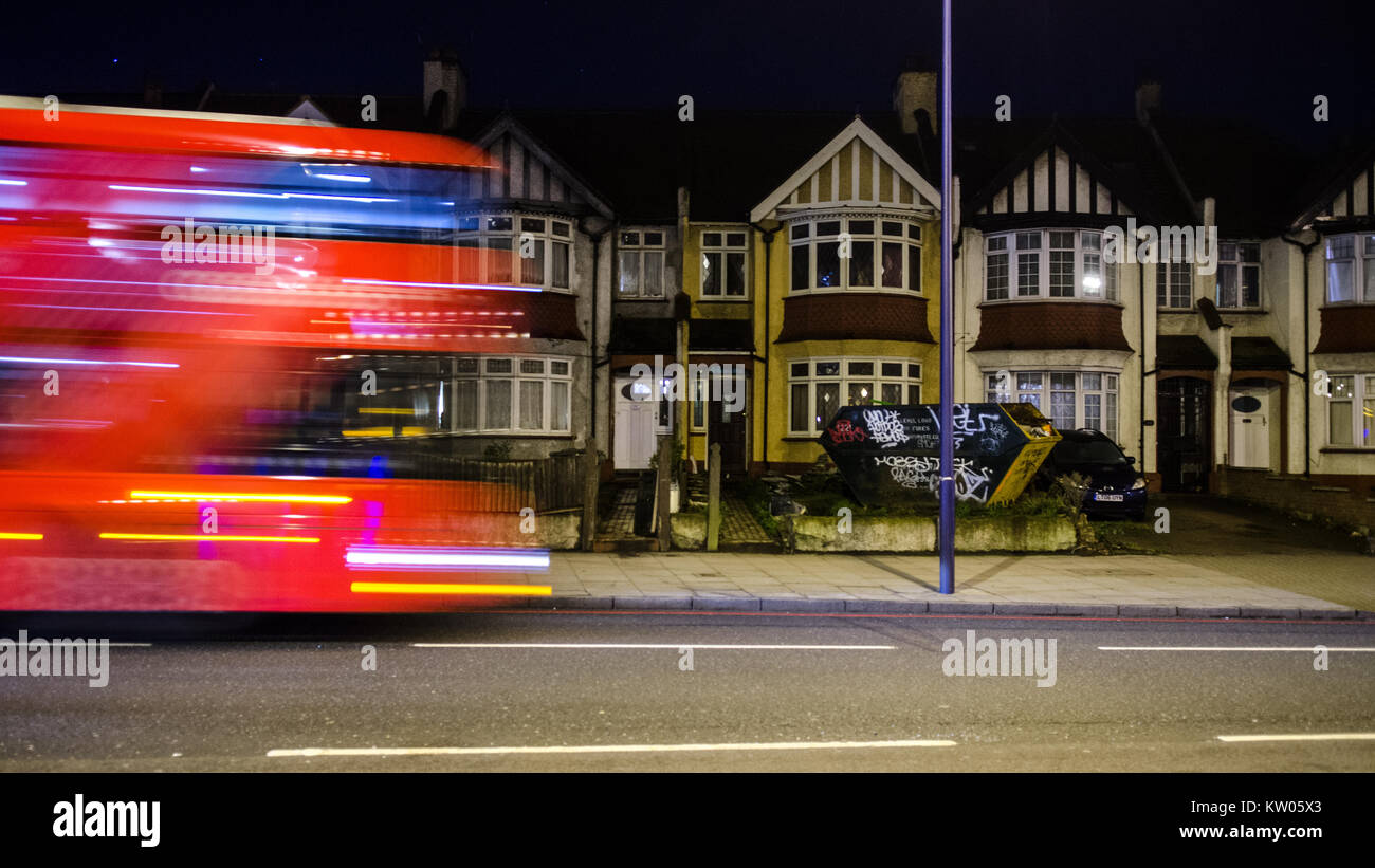 London, England, Regno Unito - 6 Gennaio 2015: il traffico precipita lungo la trafficata New Cross Road a Londra Sud, passato file di case a schiera. Foto Stock