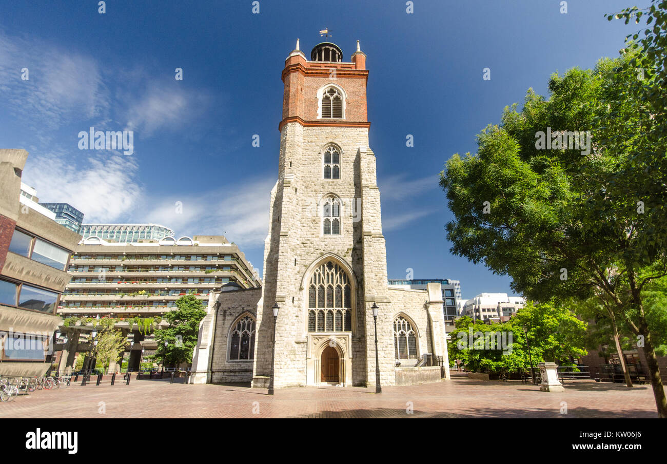 Londra, Inghilterra - Luglio 3, 2014: la parete ovest e la torre di St Giles-senza-Cripplegate, un tradizionale inglese chiesa parrocchiale in piedi entro il moderno Foto Stock