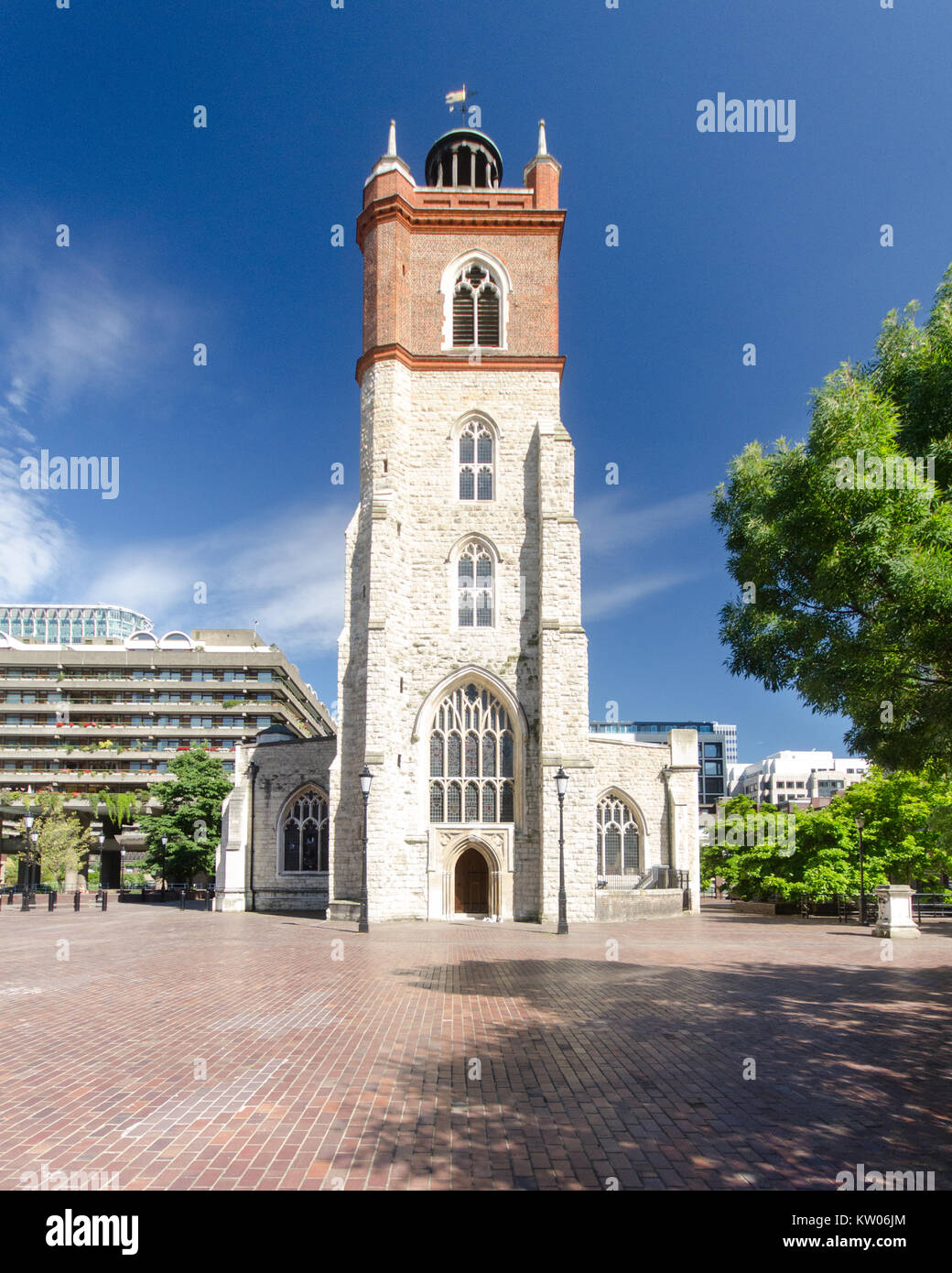 Londra, Inghilterra - Luglio 3, 2014: la parete ovest e la torre di St Giles-senza-Cripplegate, un tradizionale inglese chiesa parrocchiale in piedi entro il moderno Foto Stock