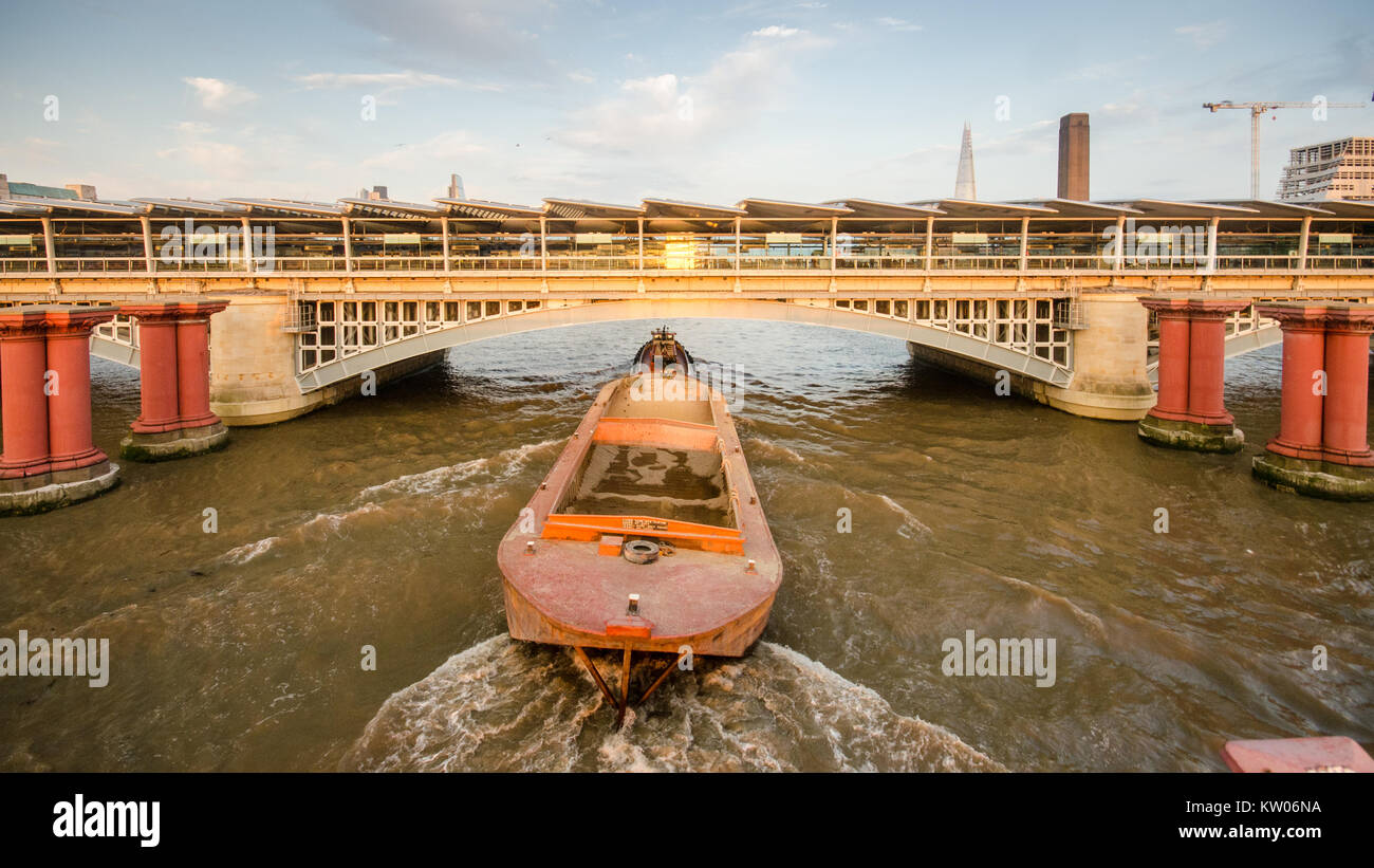 London, England, Regno Unito - 15 Settembre 2014: un rimorchiatore di matasse di una bettolina sul Fiume Tamigi sotto il Blackfriars Stazione ferroviaria nella città di Londra. Foto Stock