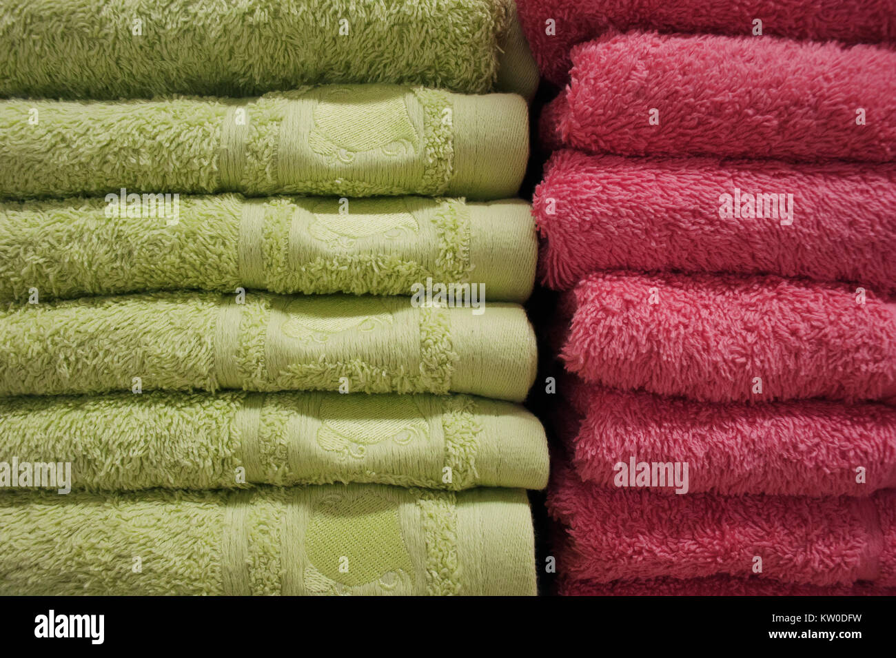 Asciugamani da bagno di colori luminosi in una fila in una fila sul contatore di un contatore del negozio. Vendita Foto Stock