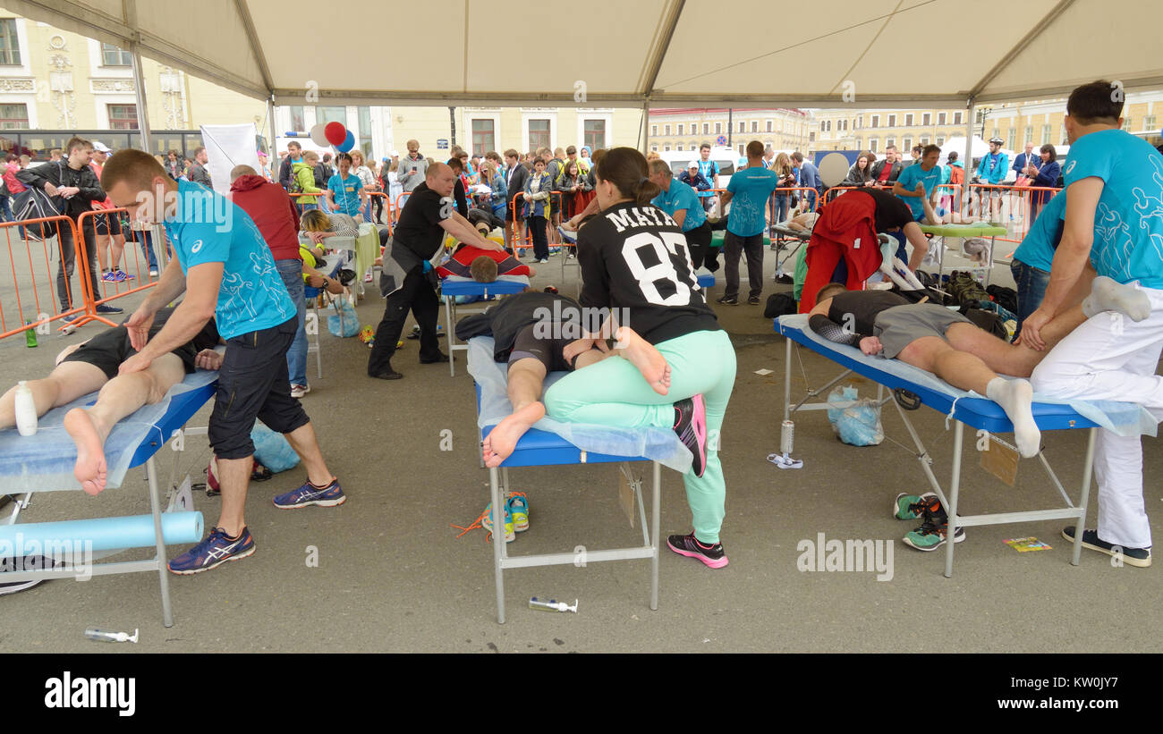 09.07.2017.Russia.San Pietroburgo.Sport massaggi terapeuti aiutare gli atleti dopo una gara di maratona. Foto Stock