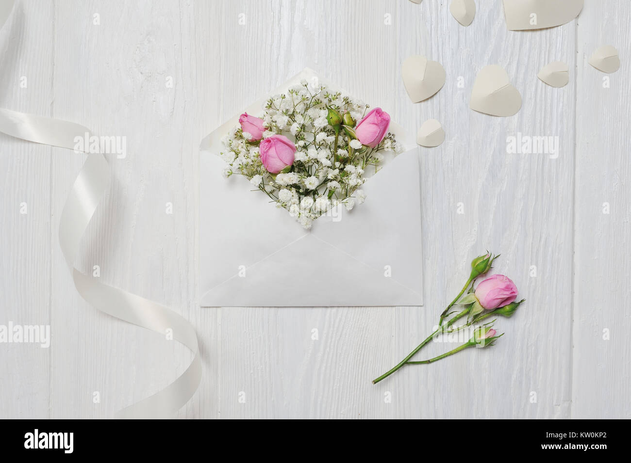 Mockup Lettera con fiori rosa per il giorno di San Valentino in stile rustico con posto per il vostro testo, Piana, laici top view photo mock up. Foto Stock