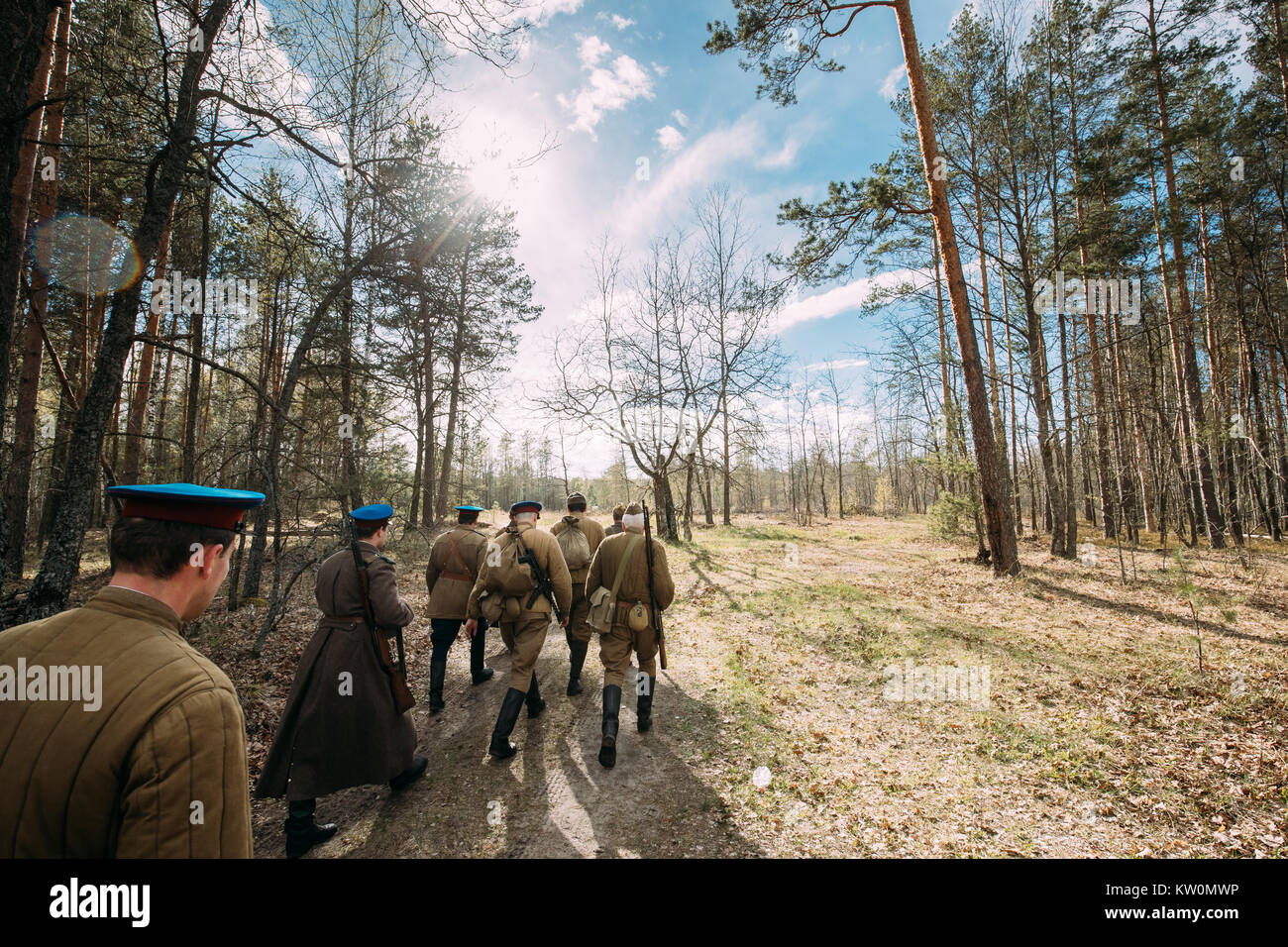 Gruppo di re-enactors vestito come Soviet russo Rosso esercito di soldati di fanteria della II Guerra Mondiale in marcia lungo la strada forestale in estate stagione autunnale. Foto Stock