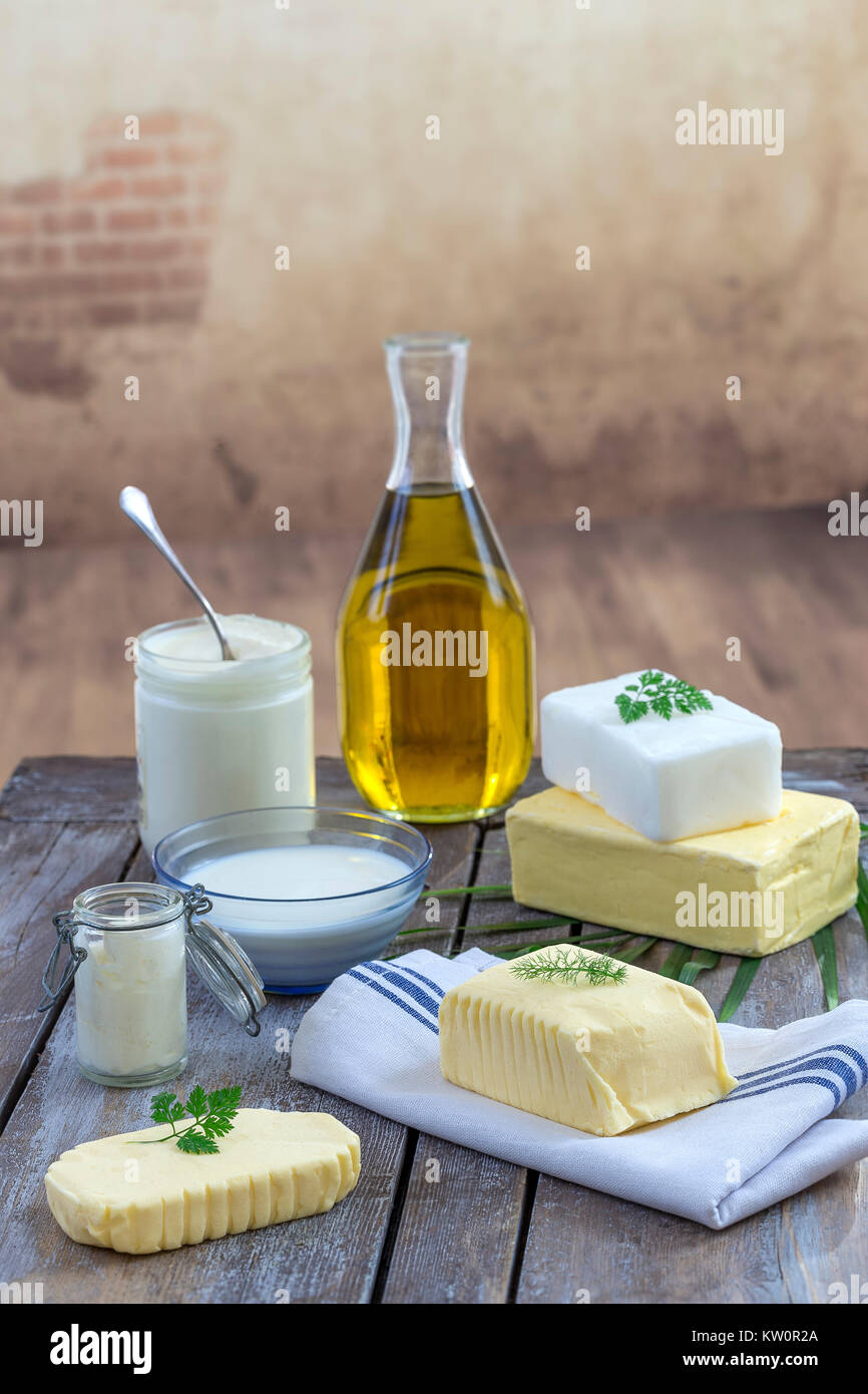 Grassi alimentari e olio : insieme di prodotti lattiero-caseari e olio e grassi animali su uno sfondo di legno Foto Stock