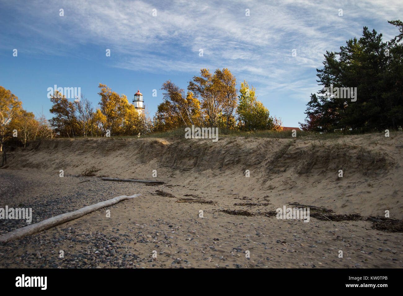 Spiaggia di sabbia sulla costa del lago Superior con il coregone Point Lighthouse in background incorniciato da fogliame di autunno. Penisola Superiore, Michigan, Foto Stock