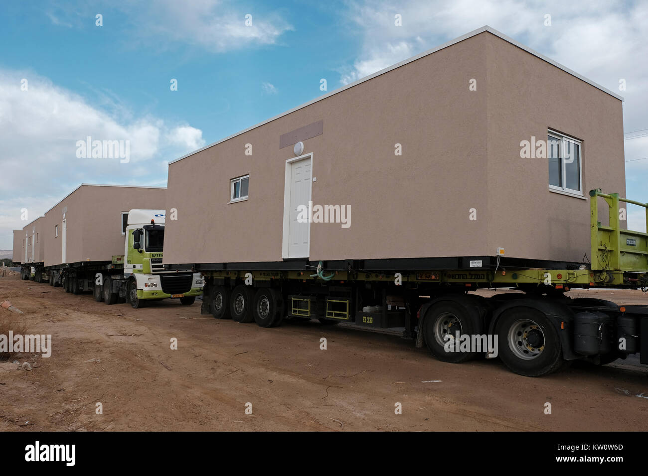 Un convoglio di camion che trasportano le case prefabbricate di nome in Israele caravillas un portmanteau delle parole caravan e villa. Caravanim sono talvolta utilizzati come economica case nel nuovo o estensioni di località esistenti all'interno di Israele. Lo stabilimento di caravanim disputata sulla terra da attivisti ebraica è considerato il primo passo verso la creazione di un insediamento israeliano. Nella sua fase iniziale di pochi caravanim, lo stabilimento è chiamato un 'avamposto.' come più i coloni si muovono in, lo stabilimento è aggiornato a un 'settlement'. Foto Stock