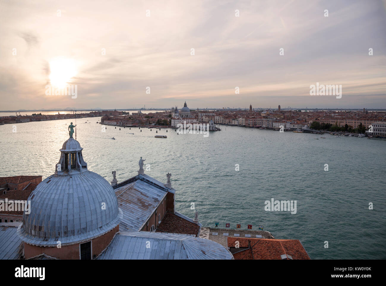 Vista serale verso il Grand Canal, Venezia, dal campanile di San Giorgio Maggiore che mostra la cupola della chiesa in primo piano e al tramonto Foto Stock