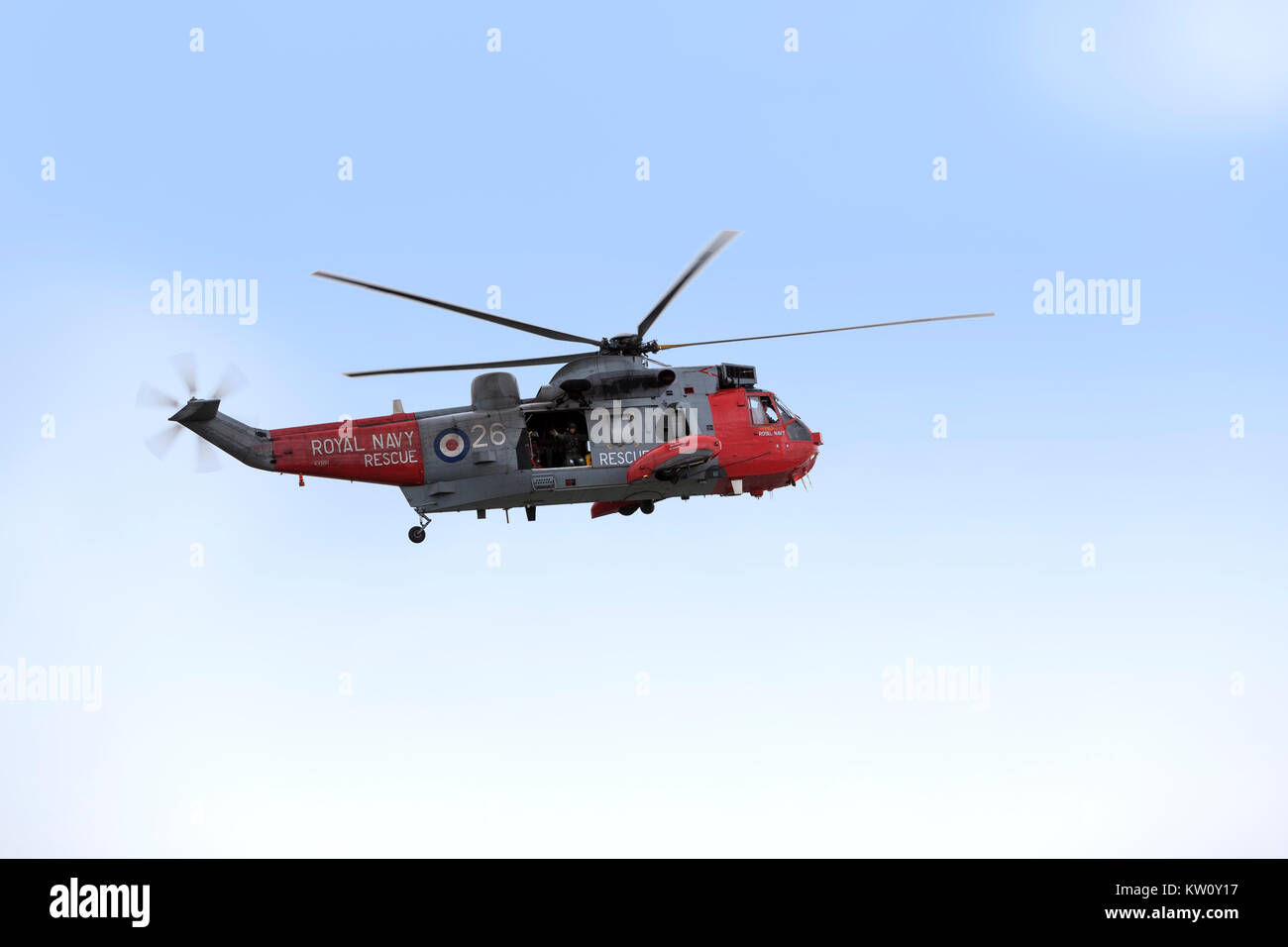 Royal Navy Sea King elicottero su una esercitazione di soccorso sotto un vago blu cielo Foto Stock
